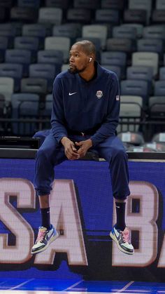 a man sitting on top of a basketball court