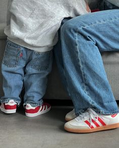 two children are sitting on a couch with their feet up against each other's legs