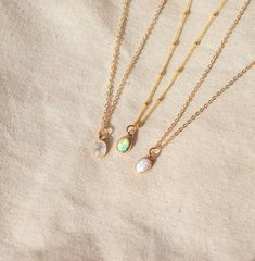 Our Dainty gemstone necklace features a tiny little stone, choose between opal, moonstone and turquoise. DETAILSGOLD VERSION:•PENDANT is Genuine Turquoise, Genuine Moonstone, or Synthetic Opal, measuring 5 x 7mm•CHAIN is 14k Gold Filled•CLASP is 14k Gold Filled Matching ………………………………….PERSONALIZE IT! ADD A STAR INITIAL CHARM:https://www.etsy.com/ca/listing/627638174/add-a-star-initial-charmADD A STAMPED INITIAL:https://www.etsy.com/ca/listing/561708083/add-an-initialADD A BIRTHSTONE:https://www.e Handmade Dainty Emerald Necklaces, Dainty Handmade May Birthstone Necklaces, Dainty Handmade Necklaces For May Birthstone, Minimalist Opal Jewelry With Delicate Chain, Dainty Moonstone Charm Necklace For Gift, Delicate Moonstone Round Pendant Necklace, Delicate Round Moonstone Pendant Necklace, Dainty Tiny Opal Jewelry, Delicate Opal Jewelry With Birthstone