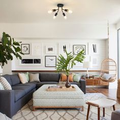 a living room filled with furniture and lots of plants on the wall next to it