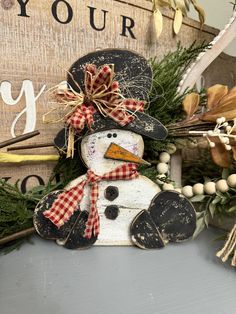 a wooden snowman sitting on top of a table