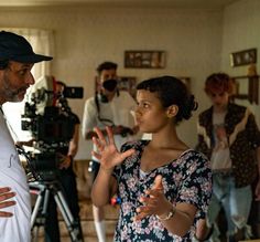 a man standing next to a woman in front of a camera