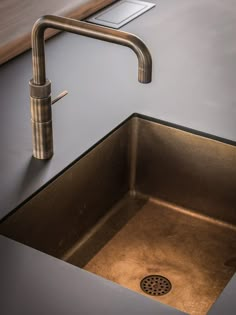 a kitchen sink with a faucet in the middle and a drain on the side