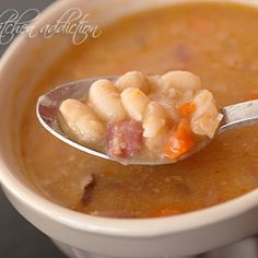 a spoon full of soup with beans and ham