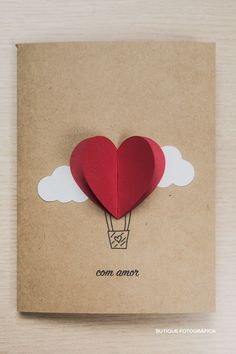 a card with a heart shaped hot air balloon in the sky on top of it