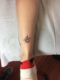 a person's foot with a small tattoo on the left side of their leg