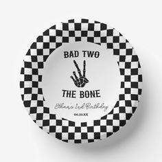 a black and white checkered plate with the words bad two, the bone on it