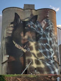 a large painting on the side of a building with a dog and man holding a knife