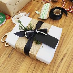 a wrapped present sitting on top of a wooden floor next to ribbon and other items