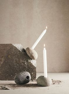 some rocks and two candles sitting on top of each other