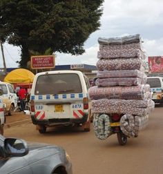 there are many bags on the back of a motorcycle and cars driving down the street