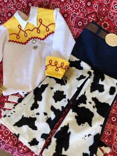 two children's clothing items sitting on top of a red and white carpeted floor