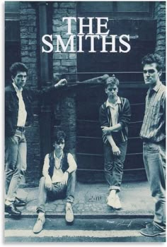 the smiths posing for a photo in front of a brick building