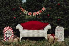 a white couch sitting on top of a lush green field next to a christmas tree