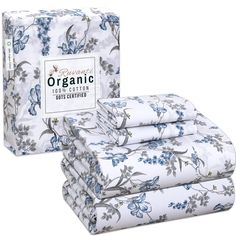 the organic sheet set is white with blue flowers on it and has four folded sheets