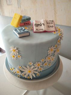 a cake decorated with books and daisies