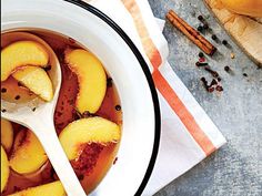 a white bowl filled with sliced peaches on top of a table