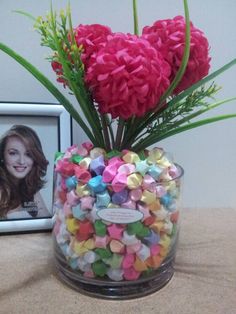 pink carnations in a glass vase filled with conversation hearts and a framed photo