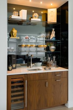 a kitchen with wooden cabinets and glass shelves