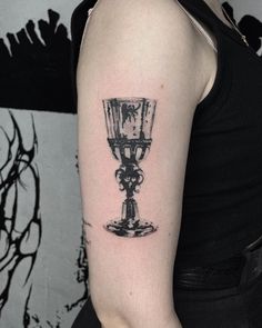 a woman's arm with a small tattoo of a wine glass on her left arm