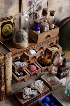 an old dresser with many items on it and some glass bottles in the bottom drawer