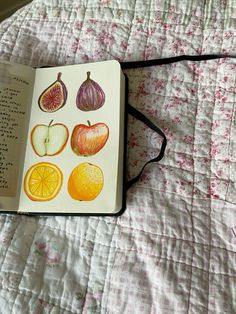 an open book sitting on top of a bed covered in fruit and veggies