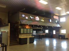 the inside of a building with many signs on the wall and lights hanging from the ceiling