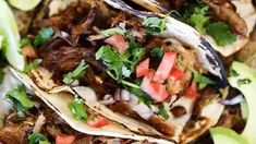 several tacos with meat and vegetables on them