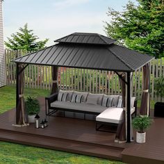 a gazebo sitting on top of a wooden deck next to a white couch and potted plant