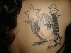 the back of a woman's shoulder with an anime tattoo on it