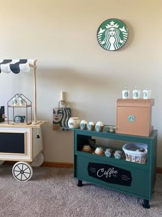 there is a small cart with cups on it and a starbucks sign above the cart