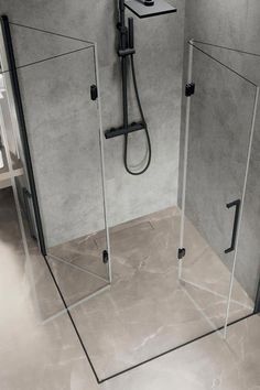 two glass shower stalls in a bathroom with grey walls and tile flooring on the side