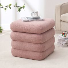 a stack of pink towels sitting on top of a white floor next to a chair