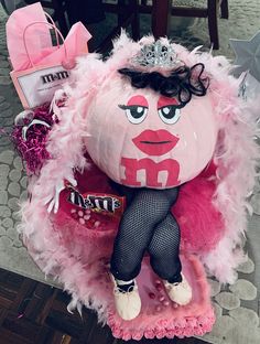 a pink stuffed animal with a tiara on it's head and some candy