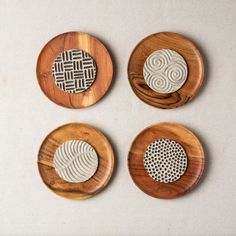 four wooden plates with decorative designs on them