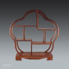 a wooden shelf with three shelves on each side and an intricate design in the middle