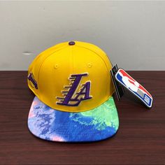 the los angeles lakers tie - dye hat is next to a card holder on a table