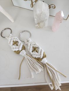 two tasselled keychains sitting on top of a table next to crystals