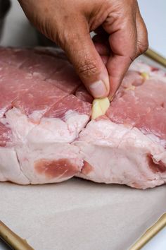 a person is cutting meat into pieces on a tray