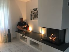 a man sitting in front of a fire place