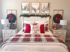 a bedroom decorated for christmas with plaid bedding and red pillows, wreaths on the headboard