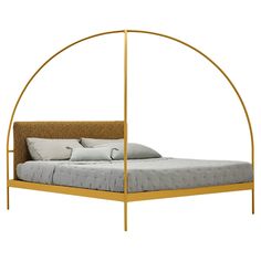 a bed with a gold frame and pillows on it's side, in front of a white background