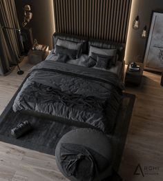 a large bed with black sheets and pillows in a dark colored room, surrounded by wooden flooring