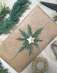 a wrapped present sitting on top of a table next to christmas wreaths and scissors