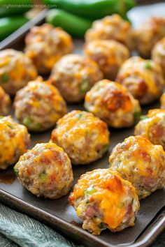 meatballs with cheese and green peppers on a baking sheet, ready to be eaten