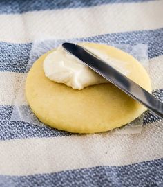 a cookie with cream frosting on it and a spoon resting on the top one