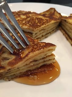 a plate with pancakes and caramel syrup being drizzled on them by a fork