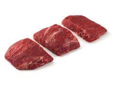 three pieces of raw meat sitting on top of each other in front of a white background