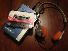 an old cassette player and headphones on top of a wooden table next to books