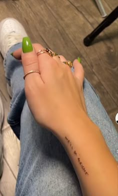 a woman's hand with a green manicure on her left wrist and the word love is written on it